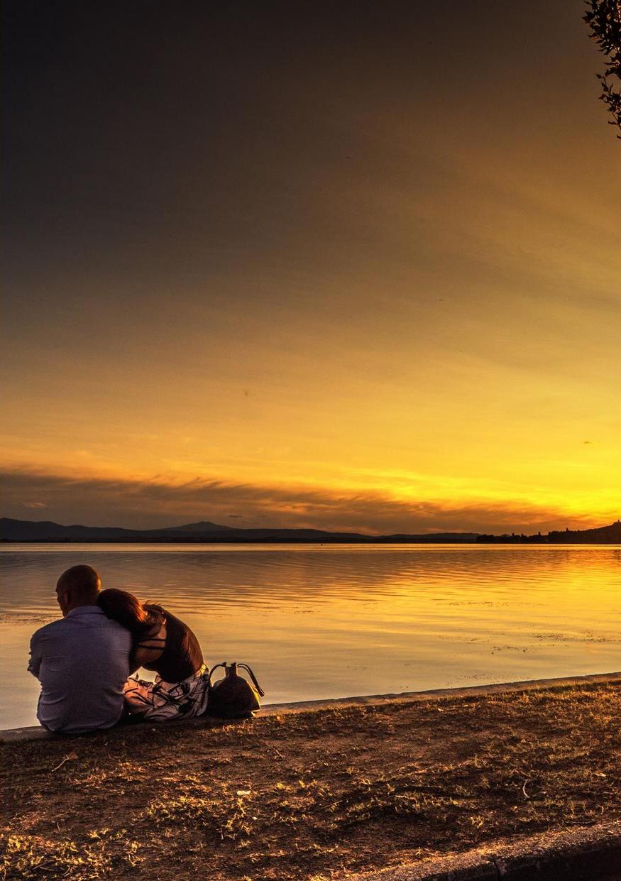 Event poster with a sunset over Lake Trasimeno in the background