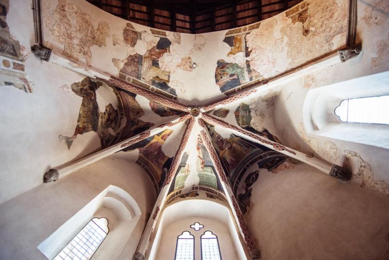 Volte affrescate della Chiesa di San Francesco a Montone, con scene sacre medievali e finestre gotiche.