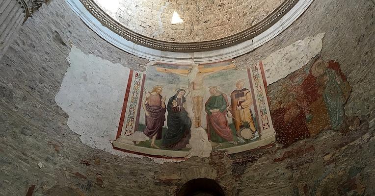 Frescoes with sacred figures at the foot of the crucifix on the semicircular wall of the apse in the Basilica of San Salvatore.