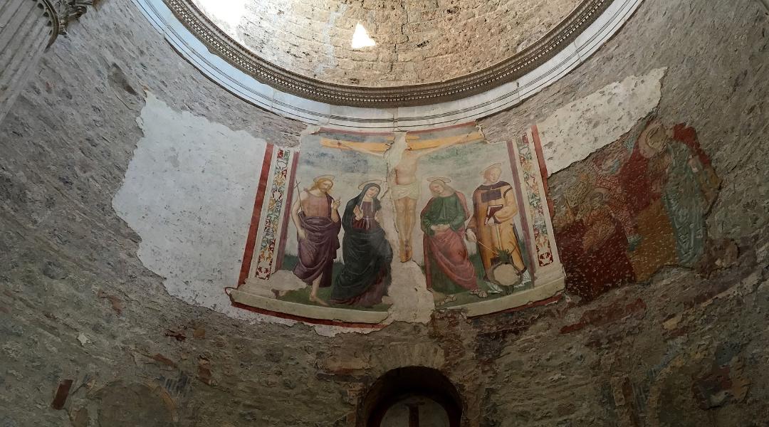 Abside in pietra con affresco raffigurante la Crocifissione, colonne corinzie e decorazioni architettoniche.