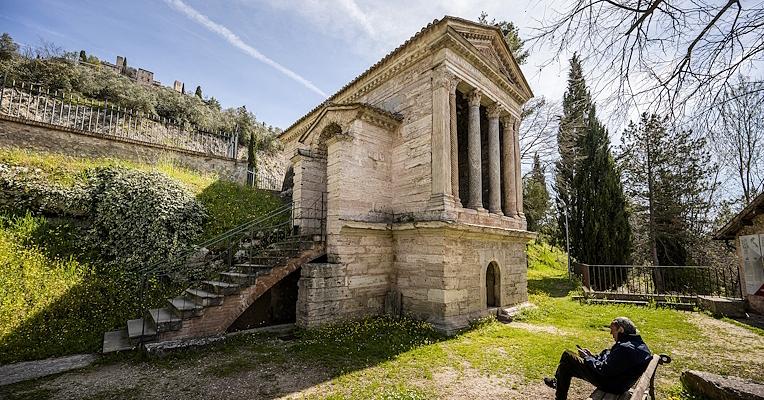 View of the Temple of Clitunno surrounded by greenery, with a front of four columns and side entrance