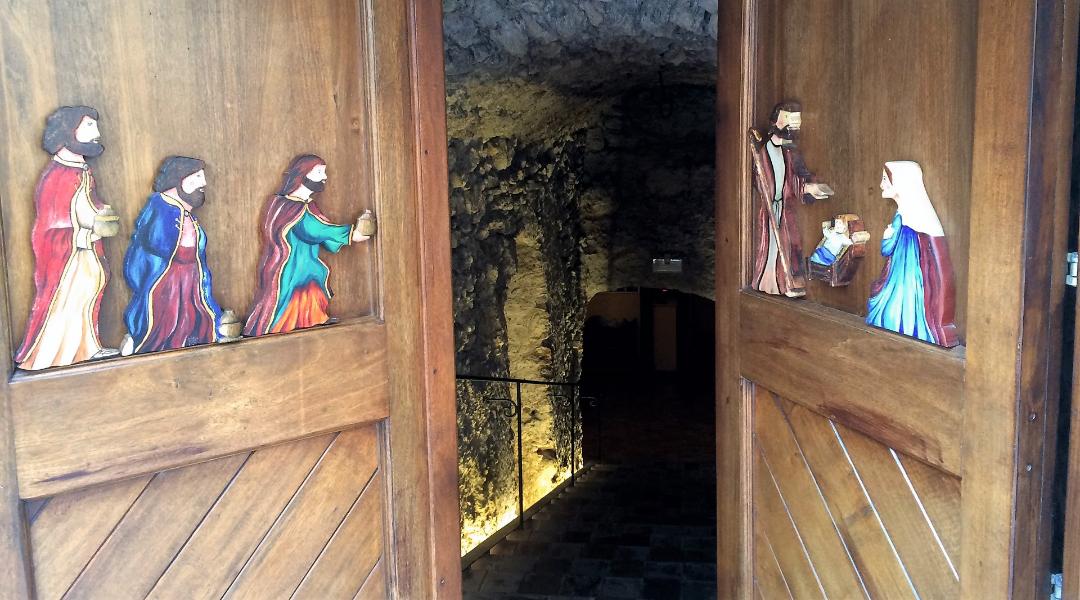 Ingresso al presepe de La Penna con le porte semi aperte che lasciano intravedere la scalinata scavata nella roccia