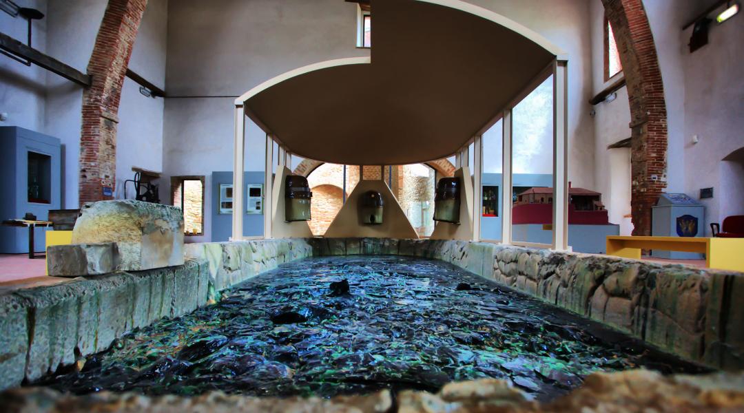 L'ambiente interno ospita una suggestiva colata di vetro, lasciata solidificare dall'ultima fusione, a ricordo del processo di lavorazione