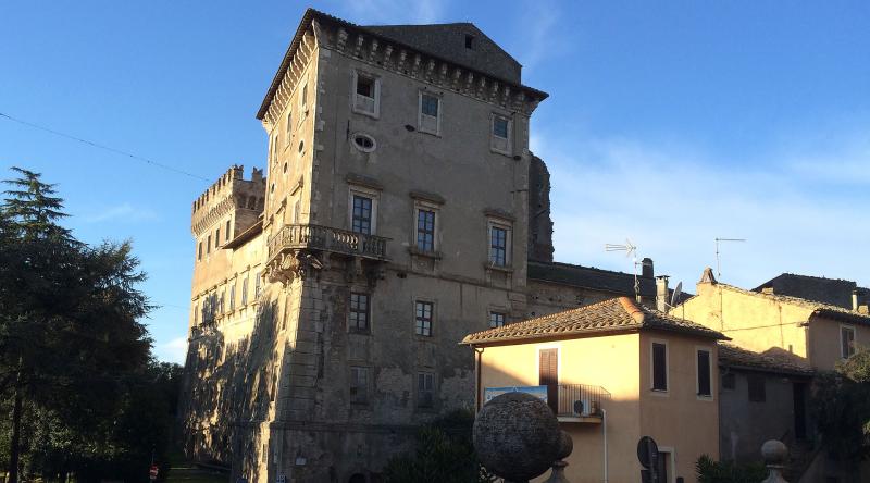 Castello di Giove, antico palazzo fortificato in pietra con torre, illuminato dal sole al tramonto nel borgo umbro.