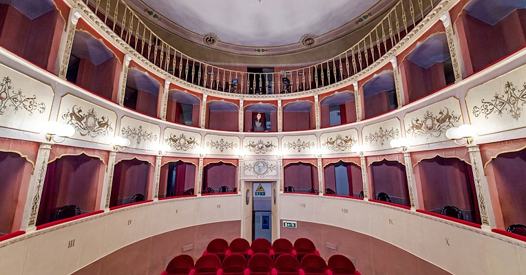 Palchi finemente decorati e sedute in velluto rosso nell’elegante sala settecentesca del Teatro Caporali di Panicale.