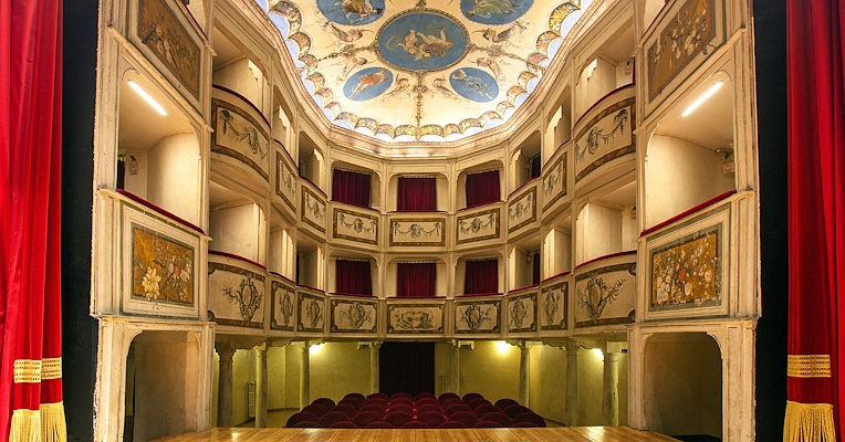 Interno del Teatro della Concordia di Monte Castello di Vibio, con palchi affrescati, sipario rosso e soffitto decorato