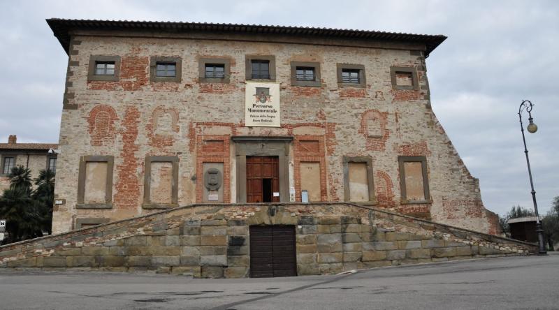Facciata principale del Palazzo della Corgna a Castiglione del Lago, caratterizzata da mattoni a vista e una scalinata d'ingresso.