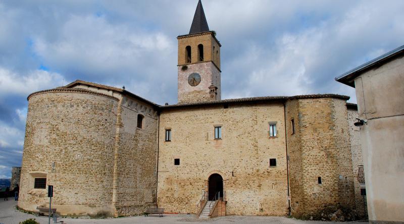 Uno sguardo interno all’edificio, tra nicchie e dipinti L’interno della chiesa si presenta con un’unica navata ampia e luminosa, caratterizzata da un soffitto molto alto che accentua il senso di verticalità e solennità dello spazio sacro interno.  In fondo alla navata, dove è conservato un affresco del 1508 staccato dalla parete originaria che raffigura la Madonna col Bambinoin una mandorla, si trovano due nicchie laterali:  Prima nicchia di sinistra: i resti di affreschi di difficile lettura decorano le pareti laterali. Sulla sinistra è presente la tela che raffigura la Madonna Addoloratae san Gregorio Magno, con un cherubino che regge un cartiglio dove si legge la scritta “A sua maestà Carlo Martello Re di Francia”. Sull’altare è collocata una tela di XVII secolo realizzata da un pittore eugubino anonimo, dove si vedono le figure di san Gregorio Magno, sant’Antonio Abatee santa Caterina d’Alessandria. Sopra l’altare troneggia una statua lignea resa molto scura dal tempo, che probabilmente raffigura santa Marina; Seconda nicchia di sinistra: corrisponde probabilmente all’abside originale della chiesa primitiva. La volta a crociera è decorata da costolonature a fasce policrome che spiccano su uno sfondo scuro a motivi floreali. Sulla parete di fondo è presente un affresco del XV secolo che raffigura otto santi di difficile lettura. Al centro della navata, si trovano due altari:  Altare mediano di destra: ospita la statua di santa Marina, raffigurata mentre tiene in braccio il bimbo da lei allevato; Altare mediano di sinistra: è presente la tela seicentesca con la Madonna del Rosarioaffiancata da san Domenico, santa Caterina da Siena, san Francesco d’Assisi e san Carlo Borromeo, opera di Giovanni Francesco Romanelli. Il presbiterio, rialzato da gradini e introdotto da un arco impostato su colonne, precede l’altare maggiore e custodisce alcune delle opere più preziose della chiesa:  Nicchia di destra: pregevole affresco del 1512 che reca la firma di Tiberio di Assisi, discepolo del Perugino, riportato alla luce nel 1896. Nel registro inferiore sono raffigurati l’arcangelo Raffaele che tiene per mano il giovane Tobiolo, seguito da santa Caterina e, sulla destra, san Silvestro I Papa in abiti pontificali che sovrasta il dragone ucciso al Monte Soratte. Nella calotta è raffigurato l’Eterno benedicente con il globo nella mano e un arco iridescente, circondato da nubi dorate e affiancato da nove serafini e due angeli. Altare di sinistra: dedicato alla Madonna del Soccorso, custodisce una delle opere più interessanti dell'edificio: la Vergine del Soccorso. Abbigliata in un ampio manto stellato, la Madonna libera un bambino dalle grinfie del demonio. La tradizione popolare racconta che l’immagine nasce da un episodio realmente accaduto: una madre, esasperata dal non riuscire ad addormentare il figlio, arrivò ad invocare il diavolo. Quando però questo apparve, pentita, implorò l’aiuto della Madonna, che intervenne salvando il bambino. Ai piedi sono raffigurati anche la madre e il letto del piccolo. L’opera, attribuita a Melanzio da Montefalco, “Sancta Maria populo castri Ritaldo, 1509”. In fondo alla chiesa si trovavano l’altare che è stato demolito e un crocifisso del Trecento, attualmente trasferito in sacrestia, mentre fino al 1745 dietro l’altare maggiore era presente un coro ligneo di fattura gotica.    Una santa sotto mentite spoglie Nata in Bitinia, nell’attuale Turchia, nella prima metà dell’VIII secolo, Marina trascorse una breve vita segnata dal dolore. Rimasta orfana di madre, il padre Eugenio si ritirò nel monastero di Kanoubine. Per non separarsi da lui, vestì l’abito monastico assumendo il nome di Marino, e celò la propria identità per poter condividere la vita del convento.  Durante una sosta in locanda con alcuni confratelli, fu ingiustamente accusata della violenza ricevuta dalla figlia dell’oste ma, anziché difendersi, accettò in silenzio la colpa. Fu quindi espulsa dal monastero e costretta ad accudire il neonato.  Dopo anni di umiliazioni e fatiche i suoi confratelli, che non avevano mai creduto all’accusa, riuscirono a far riammettere il giovane Marino in convento, dove gli furono affidati i lavori più umili. Consumata dalle fatiche e dalle privazioni, Marina si spense in giovane età. Solo allora, preparando il corpo per la sepoltura, i monaci scoprirono la sua vera identità, ricevendo la prova della sua innocenza, e compresero come la giovane aveva rinnegato se stessa e sopportato in silenzio l’ingiusta accusa.  Al suo capezzale giunse anche la figlia del locandiere che, tormentata dal rimorso, ottenne perdono e guarigione. Già in vita si iniziò a parlare della santità di Marina, ma dopo la morte la sua devozione si diffuse rapidamente e numerosi eventi miracolosi furono attribuiti alla sua intercessione. Il suo corpo, inizialmente sepolto nel monastero, fu condotto a Venezia, dove ancora oggi è conservato.