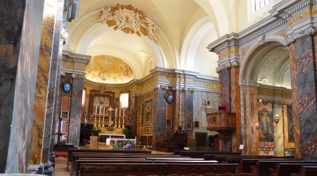 Interno della chiesa con la navata centrale, ricca di opere d’arte. Si vedono l'altare, il pulpito e le panche destinate ai fedeli.