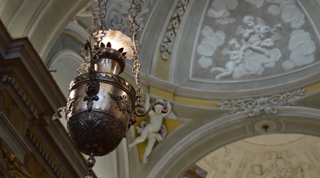 Dettaglio di un candelabro all'interno della chiesa, con bassorilievi di angeli che decorano lo sfondo.