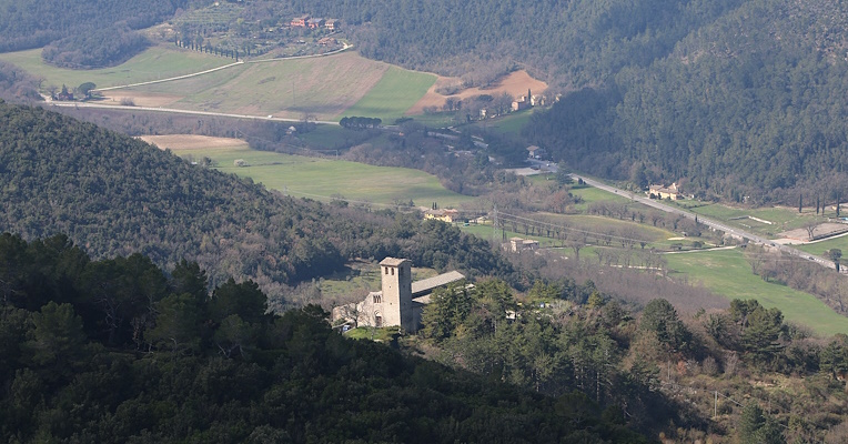 Blick von oben auf die Abtei San Giuliano, die mitten im Wald an der Straße zum Monteluco liegt
