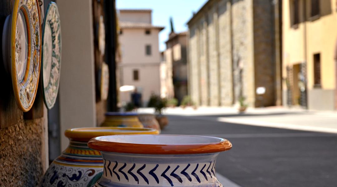 Artistic ceramics displayed along a street in Deruta’s historic centre, with stone houses in the background.
