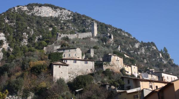  Medieval village of Ferentillo perched on the mountain, with stone houses and a fortified castle amid lush vegetation. 