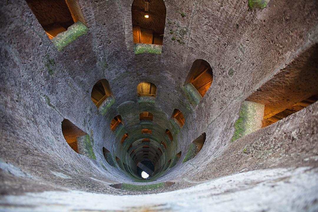 Interior view of St Patrick’s Well in Orvieto, showing its helical structure and illuminated openings.