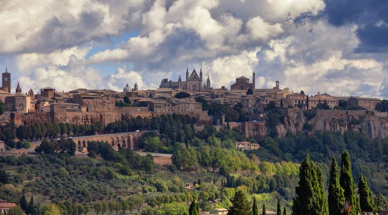 Veduta panoramica della città di Orvieto con il Duomo e le mura medievali, immersa nel paesaggio collinare umbro.