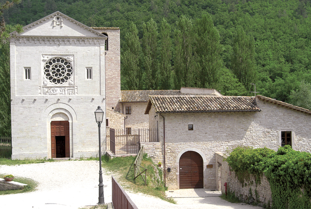 Entrée de l’église et structure de l’abbaye des Saints Feliceet Mauro. L’entrée de l’église présente un portail de style roman avec une rosace centrale.