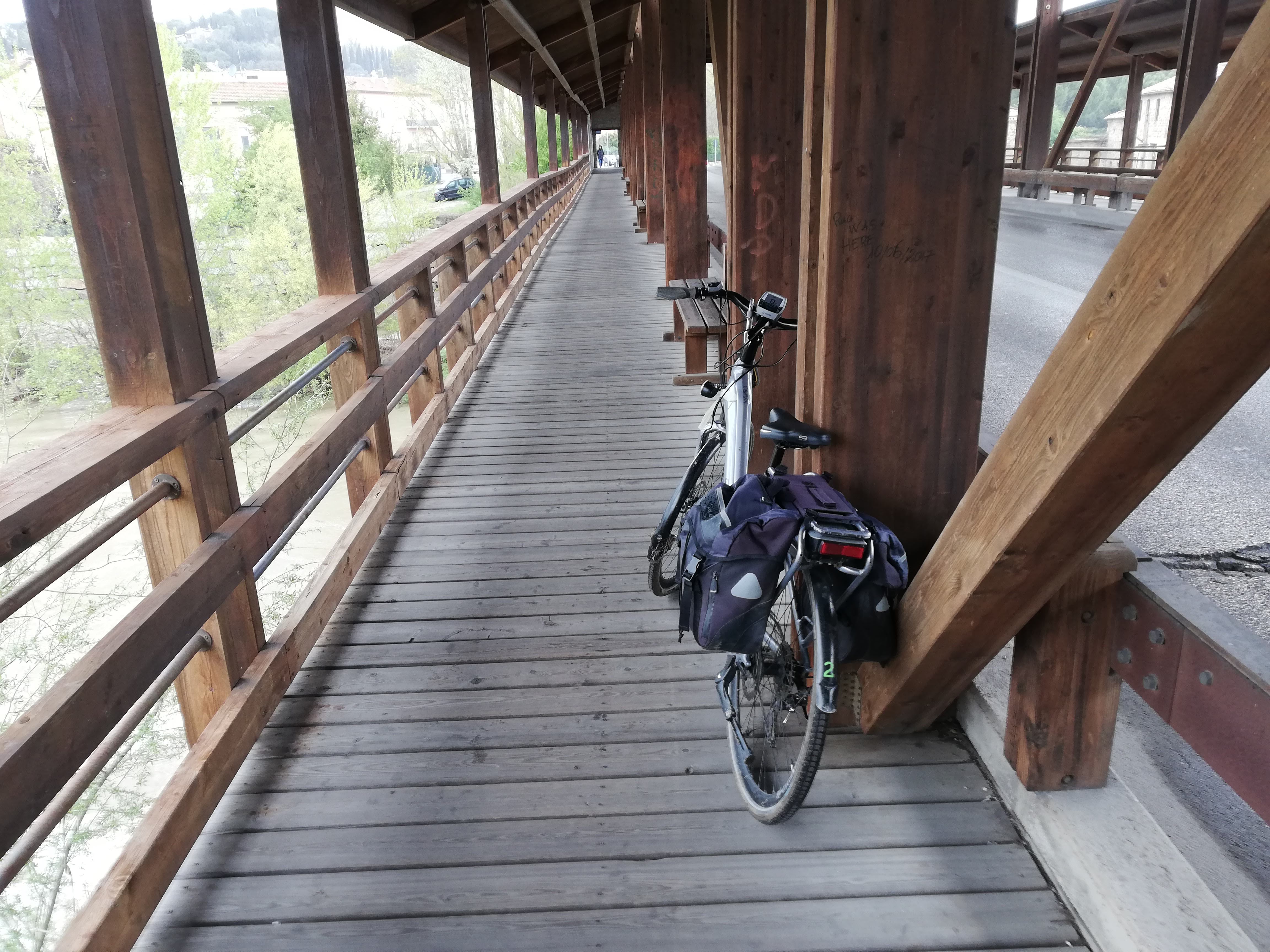 Bicycle resting on the beam of a wooden bridge along a cycle lane