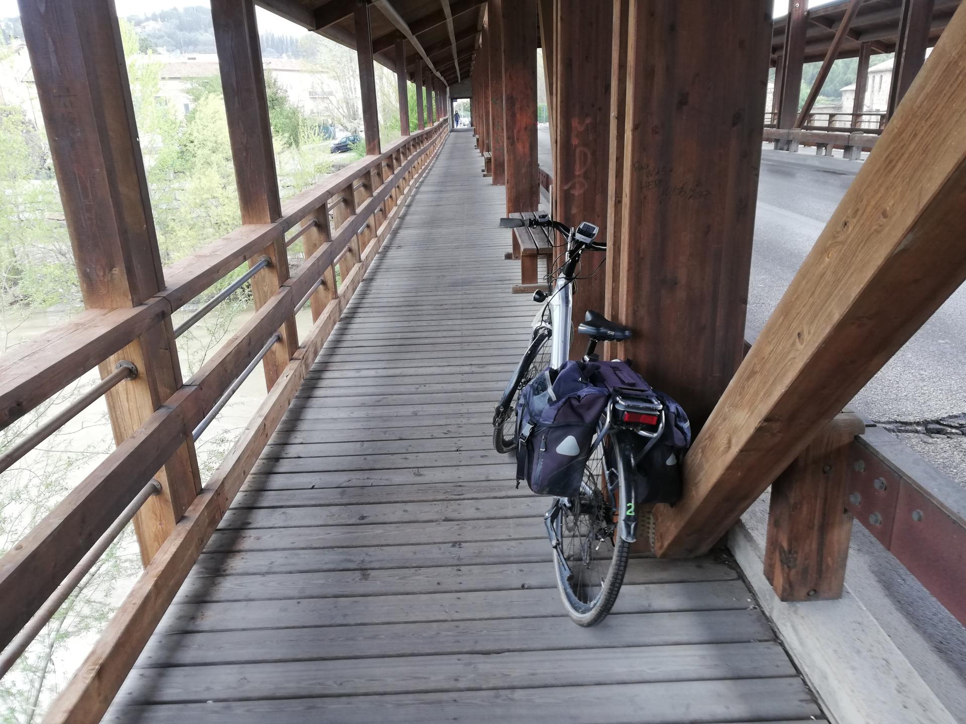 Bicycle resting on the beam of a wooden bridge along a cycle lane