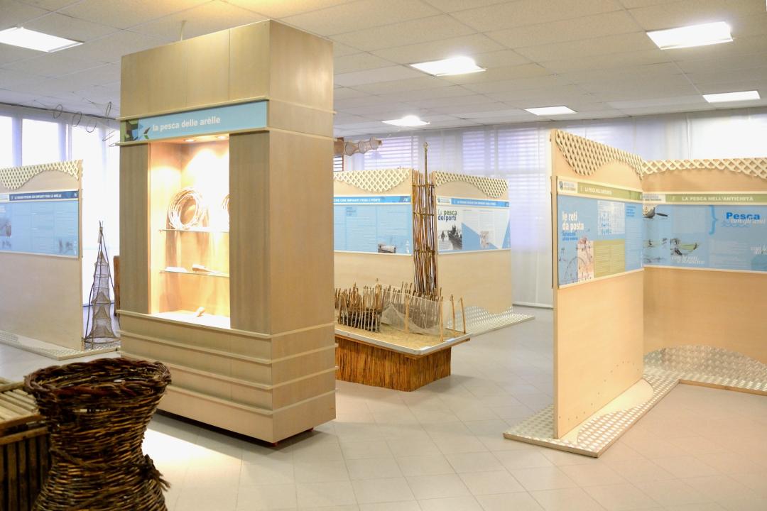 Ausstellungstafeln und traditionelle Geräte im Fischereimuseum des Trasimenischen Sees, mit Vitrinen zu Fangtechniken.