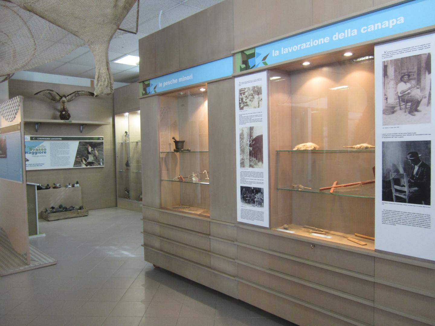 Display at the Trasimeno Fishing Museum with woven baskets, traditional tools and information panels.