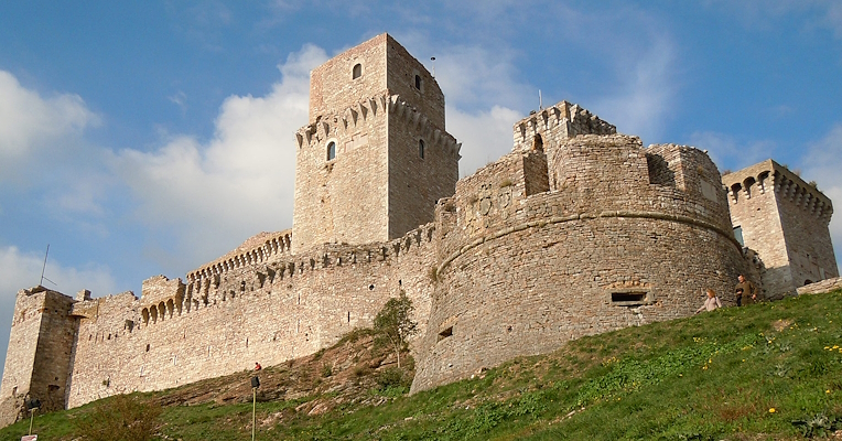 Veduta dal basso dell’imponente rocca albornoziana di Assisi, con il torrione centrale e il possente bastione circolare sulla destra