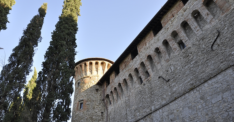 In the foreground, the imposing walls and a massive tower of the Knights of Malta Castle are visible.