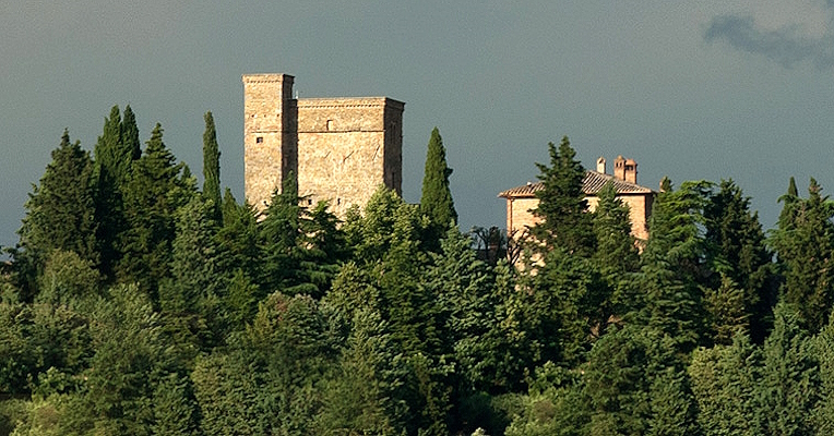 In the distance, the towers of Rocca Monaldi rise above a landscape of dense forests, creating a striking scene.