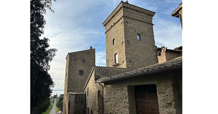 A side view of Rocca Baglioni Pompilij, a remarkable example of 14th-century military architecture, later rebuilt, showcasing ancient walls and an elegant central tower.