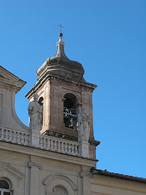 Close-up of the bell tower of the Cathedral of Santa Maria Assunta in Terni, with its Baroque dome and two statues of bishops placed on the balustrade