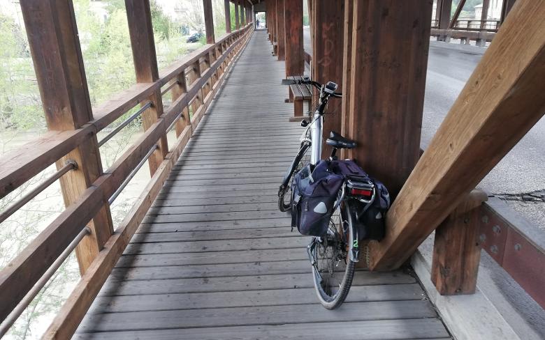  bici appoggiata sulla trave di un ponte di legno lungo una corsia ciclabile 