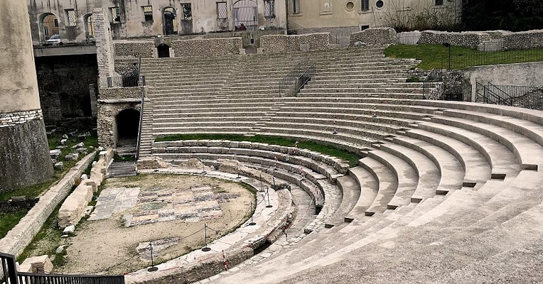 View of the Roman theatre in Spoleto, with well-preserved stone seating and remains of the orchestra