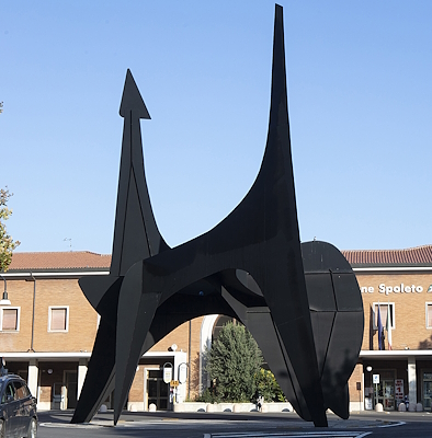 Alexander Calder’s modern art work “Teodelapio”, black in colour, with Spoleto’s railway station behind it