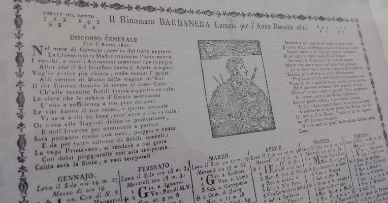 Riproduzione di un almanacco Barbanera del 1821 con calendario mensile, previsioni astrologiche e illustrazioni decorative.