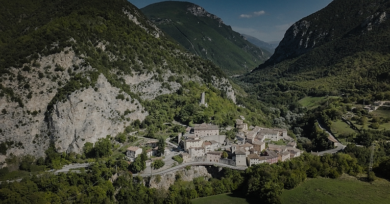 Aerial view of the medieval village of Triponzo, nestled among green mountains and wooded valleys