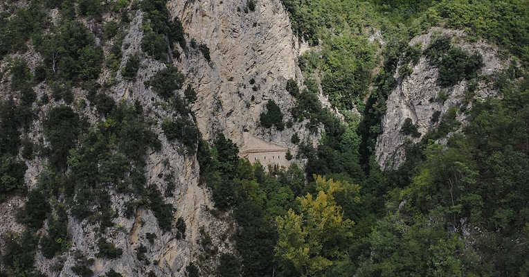 View of the rock-hewn Hermitage of Madonna della Stella, nestled among rocky peaks and lush forests