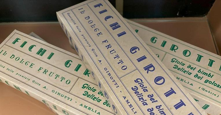 Packages of Girotti figs from Amelia with printed text in different colors.