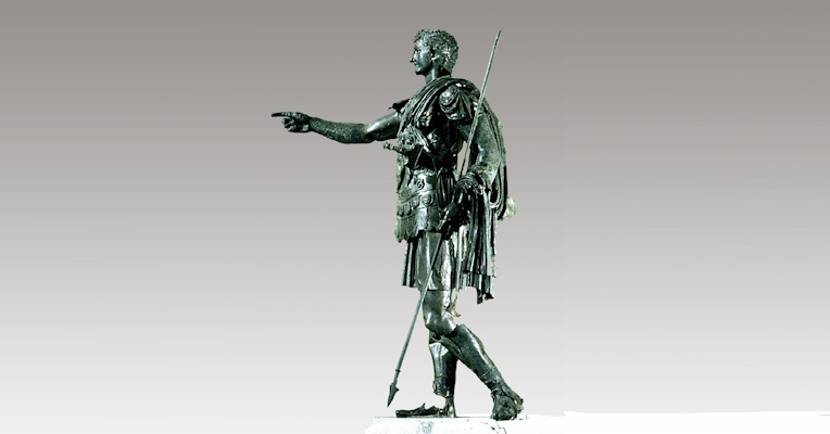  Full-length bronze statue of Germanicus, wearing armour and a cloak, with one arm extended pointing forward and a spear in the other hand. 