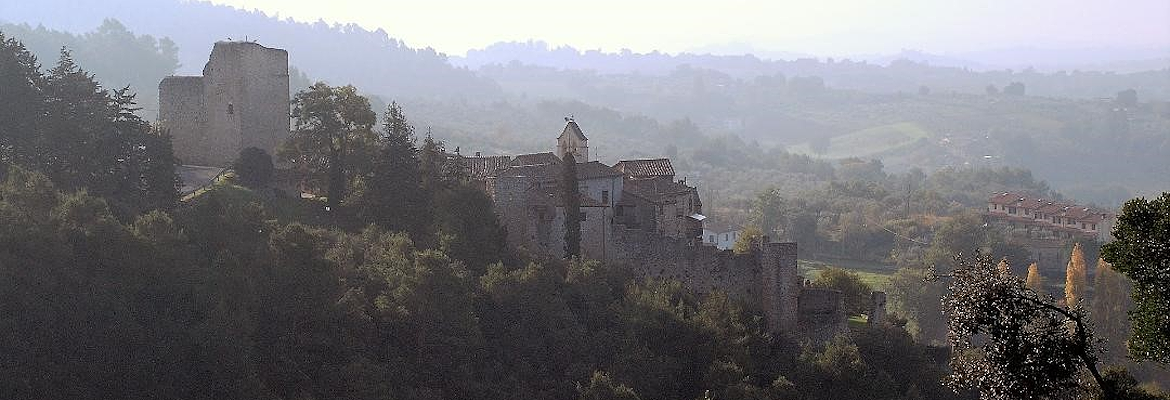 Poggio di Otricoli, an ancient fortified village, rises among Umbrian woods and hills shrouded in mist.