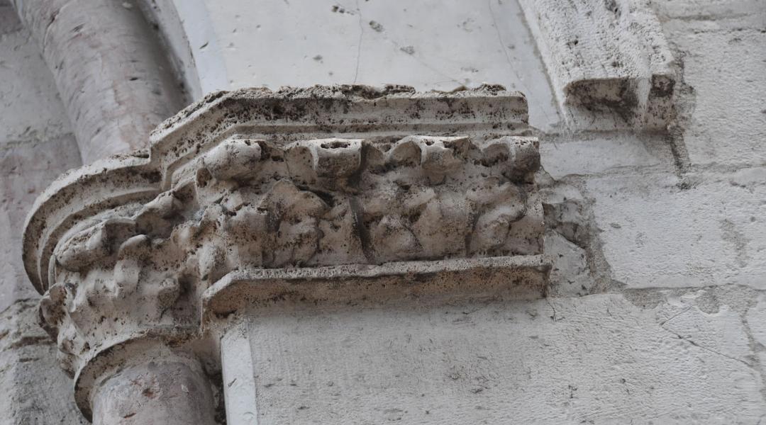 Architektonisches Detail eines steinernen Kapitells auf einer romanischen Säule der Kirche San Biagio, verziert mit floralen Skulpturen und geometrischen Motiven.