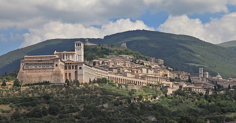  Panoramic view of Assisi with the Basilica of Saint Francesco in the foreground and historic buildings. Mount Subasio in the background 