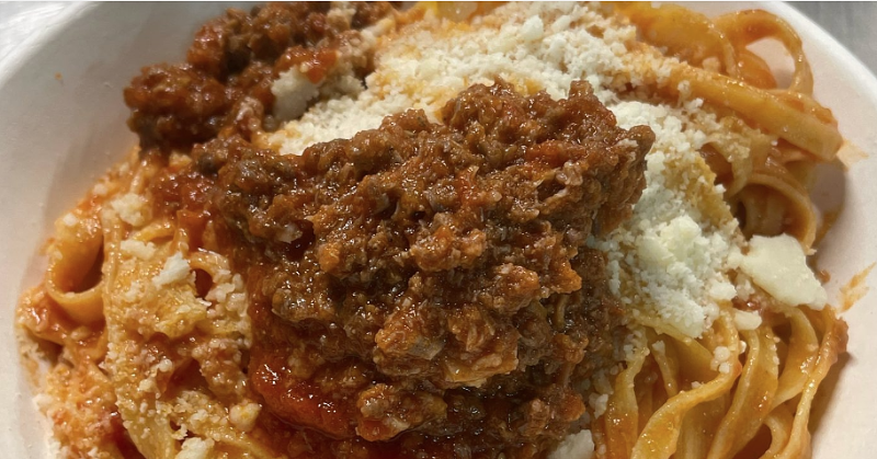 Piatto di tagliatelle fresche condite con sugo d’oca e una spolverata di formaggio grattugiato.