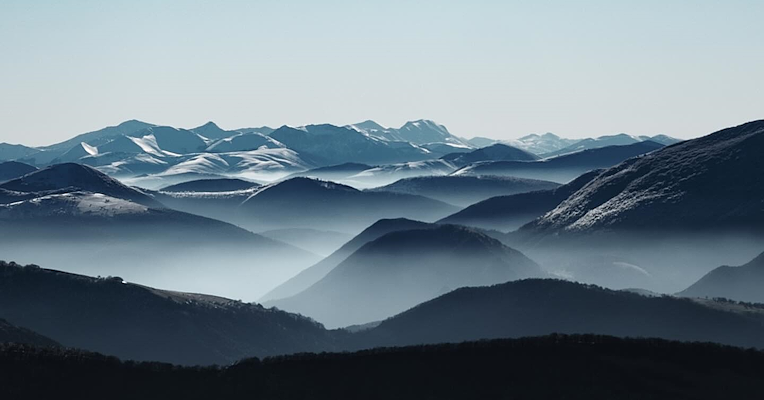 The mountains of the Monte Cucco Regional Park, shrouded in mist and winter frost.