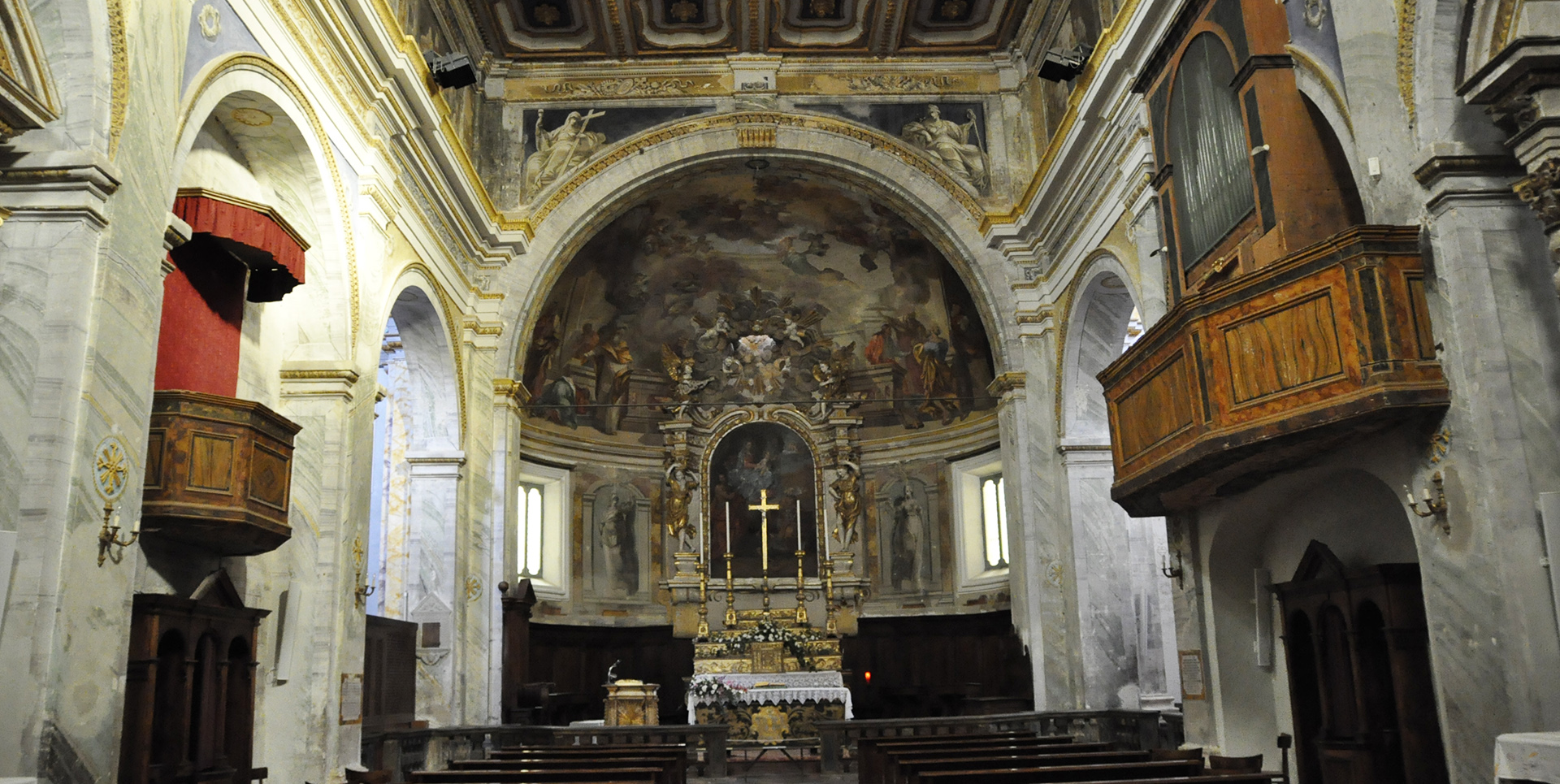 Intérieur de la Collegiata di Santa Maria Assunta e San Gregorio à Montone, avec autel baroque et fresques.