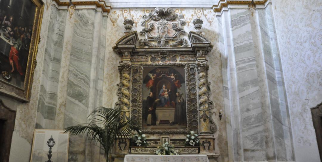 Side altar decorated with twisted columns and altarpiece depicting the Madonna in the Collegiata of Montone.