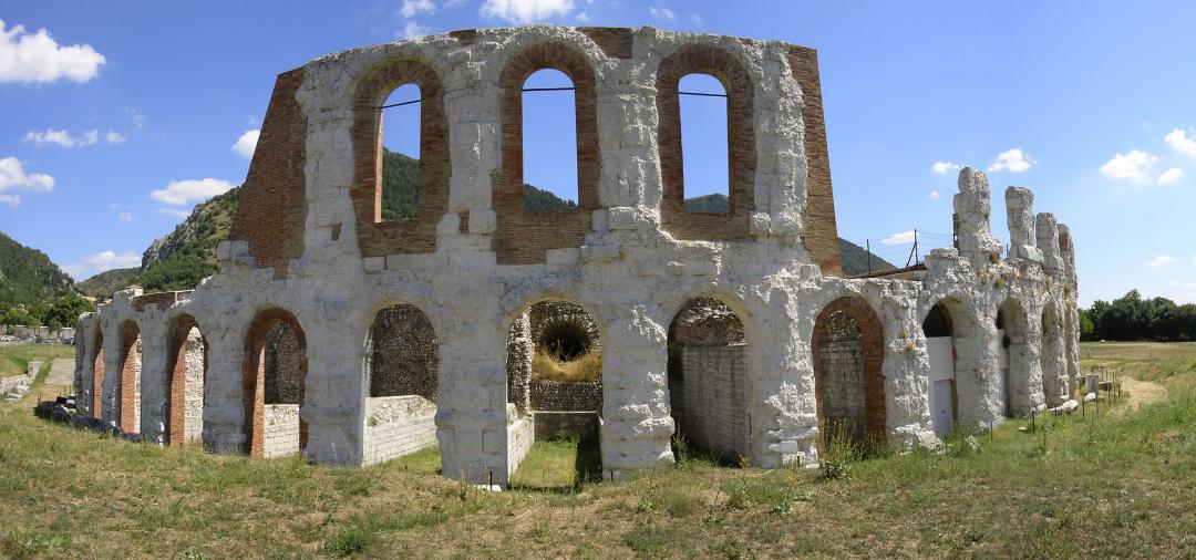 View of the exterior of the Roman theatre of Gubbio with the remains of the two tiers covered with dressed limestone stones