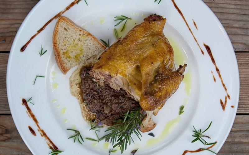 Faraona arrosto su crostone con salsa di fegatini, guarnita con rosmarino, olio d’oliva e glassa balsamica.