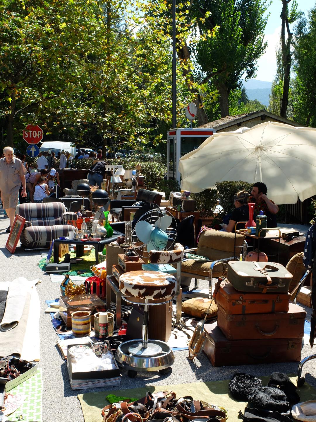 Stände eines Antiquitätenmarkts mit Keramik, Vintage-Gegenständen und Kleidung im Freien nahe den Fonti del Clitunno